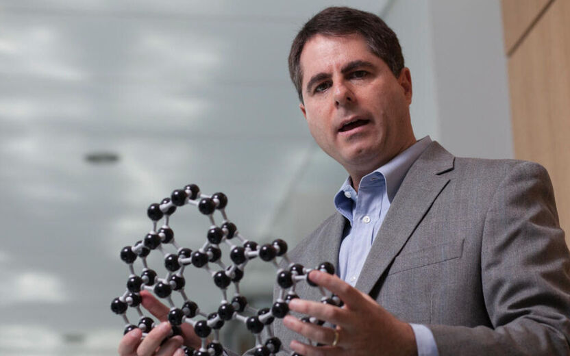 Image of a professor holding a molecular model.